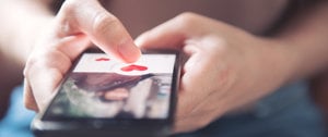 a person squeezes a heart on the phone