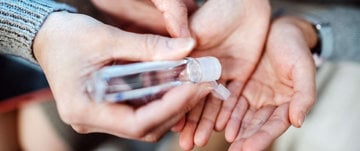 A person holding a bottle of hand sanitizer, emphasizing hygiene and health safety in everyday life.