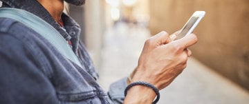 A man holding a cell phone, symbolizing the challenges of navigating digital spaces while facing depression and anxiety.