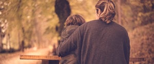 A woman and child stroll along a serene path, symbolizing family bonds amidst the challenges of migraines.