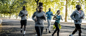 A group of runners in a park, highlighting the joy of running while promoting awareness of asthma-friendly practices.