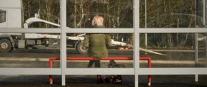 A woman seated on a bench at a bus station