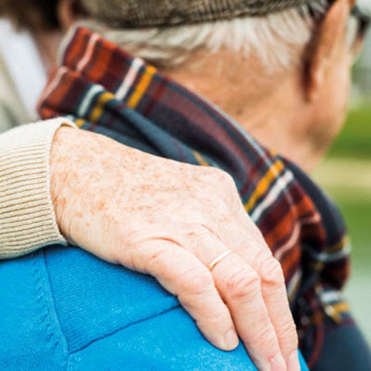 Elderly man being hugged