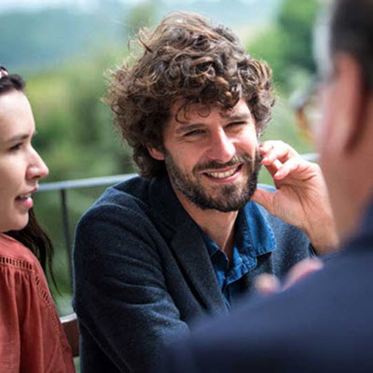 a man laughs when hanging out with friends