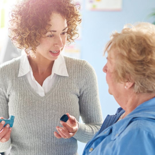 A woman engages in conversation with an older woman, fostering connections that contribute to healthy communities.